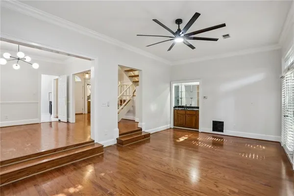 a view of empty room with wooden floor and ceiling fan