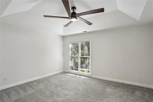 an empty room with windows and fan
