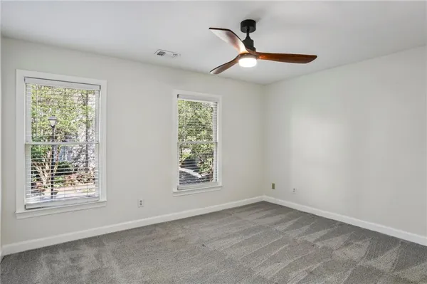 a view of empty room with window and ceiling fan