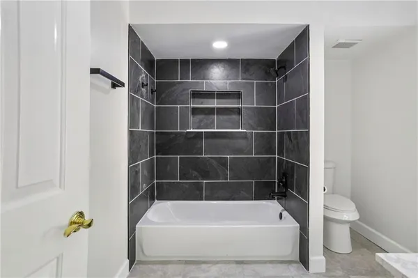 a bathroom with a bathtub and toilet