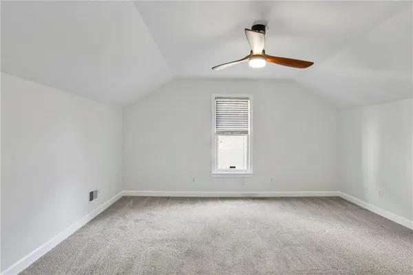 an empty room with a window and a ceiling fan
