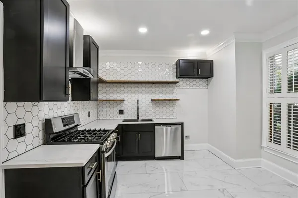 a kitchen with stainless steel appliances a sink stove and cabinets
