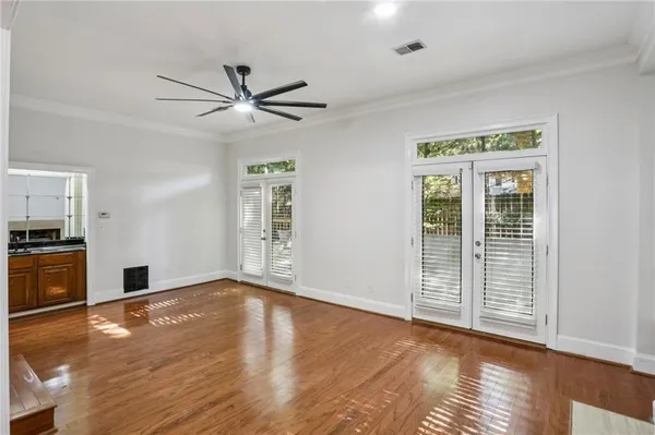 a view of empty room with wooden floor and fan