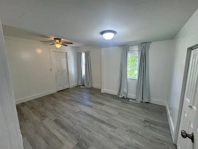 an empty room with wooden floor and window