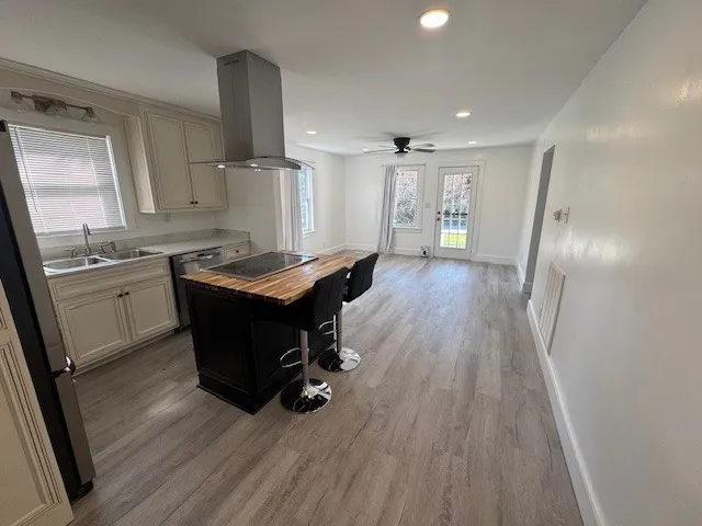 a room with wooden floors sink and cabinets