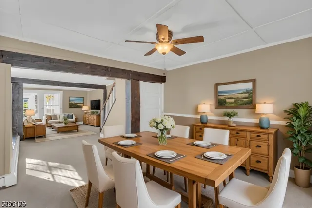 a view of a dining room and livingroom with furniture wooden floor a rug a flat screen tv