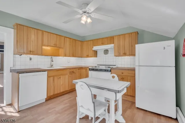 a kitchen with a refrigerator a stove a sink and cabinets