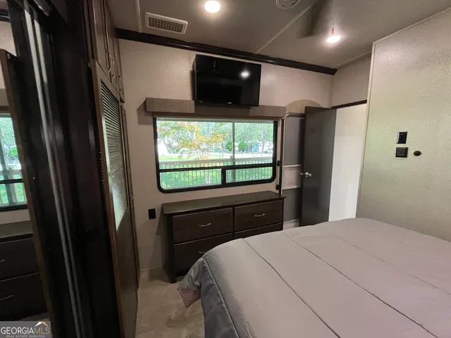 a view of a swimming pool with a bench and trees in the background