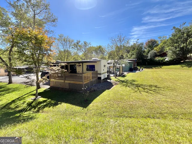 a view of a wooden deck with chairs and a yard