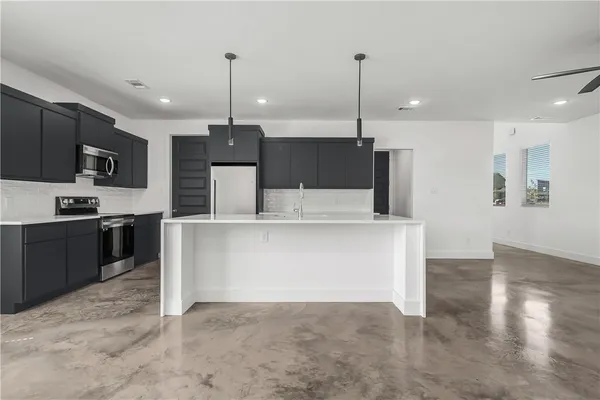 a kitchen with kitchen island a counter top space appliances and cabinets