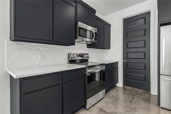 a kitchen with stainless steel appliances granite countertop a refrigerator and a stove top oven