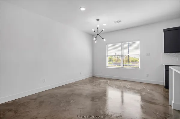an empty room with windows and fireplace