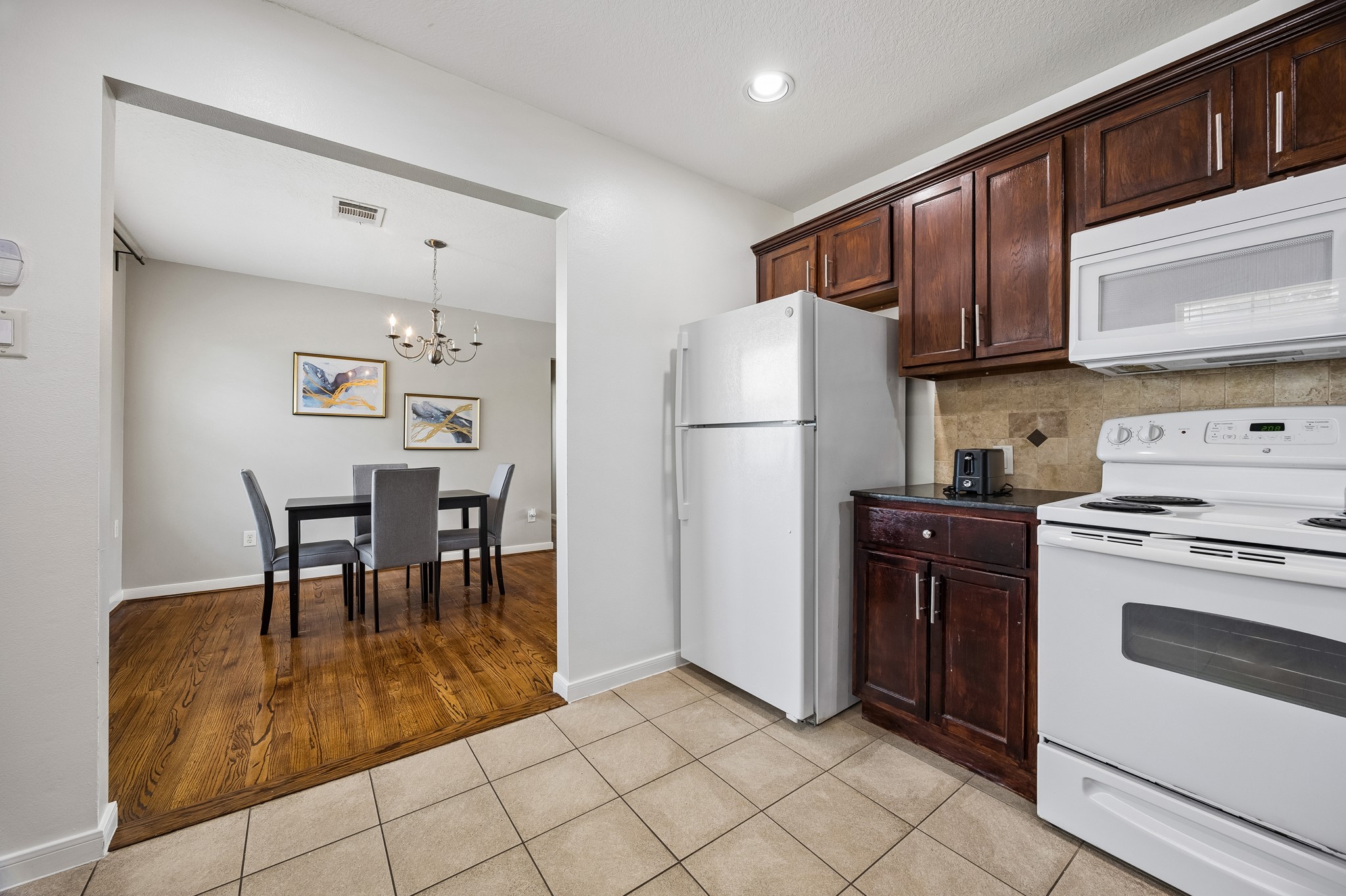 3237 Rosedale Street, Unit 4 Houston, TX 77004 - Photo 13 of 17 a kitchen with a refrigerator a table and chairs