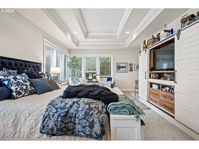 a bedroom with bed a flat tv screen and next to a window