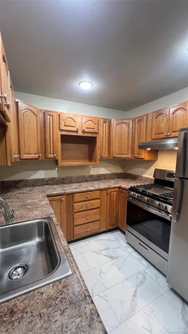 a kitchen with granite countertop a stove and cabinets