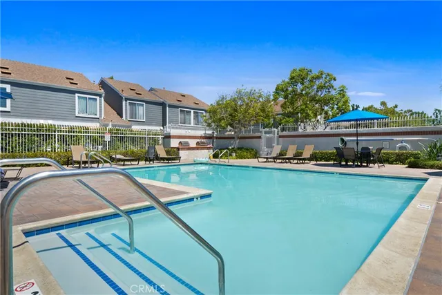 a view of a swimming pool with a patio and a yard