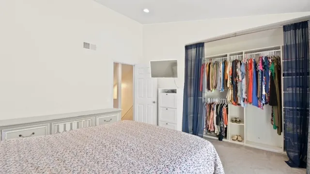 a bedroom with a bed and a large mirror