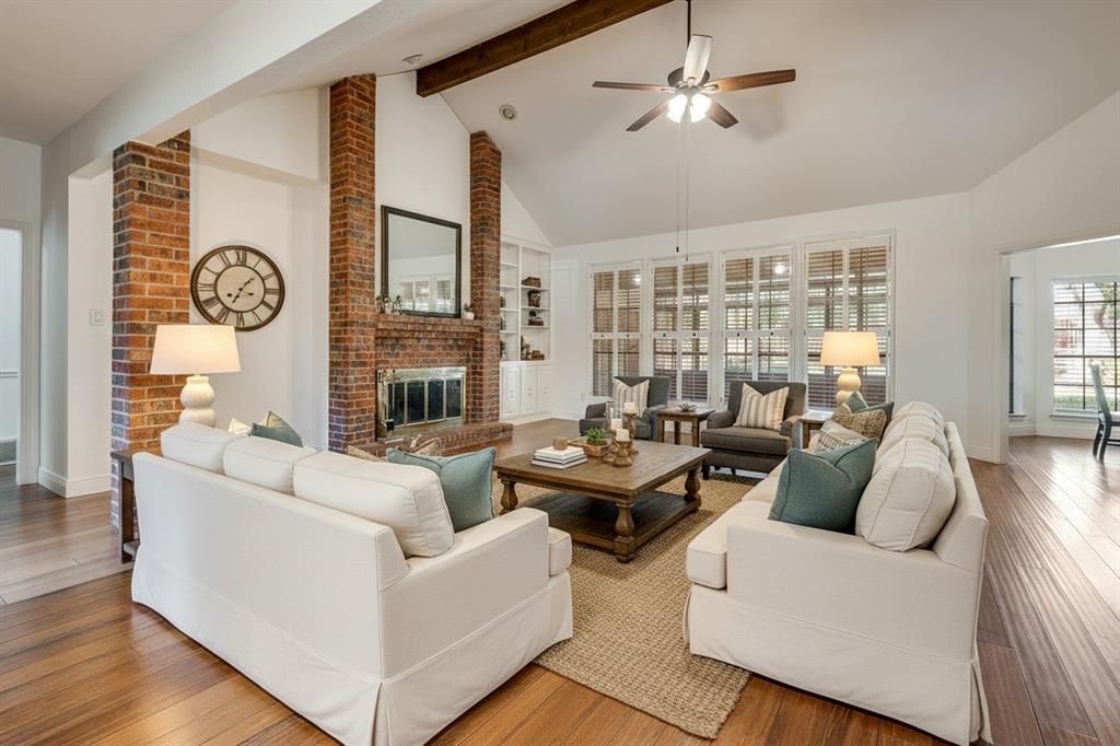 a living room with fireplace furniture and a large window