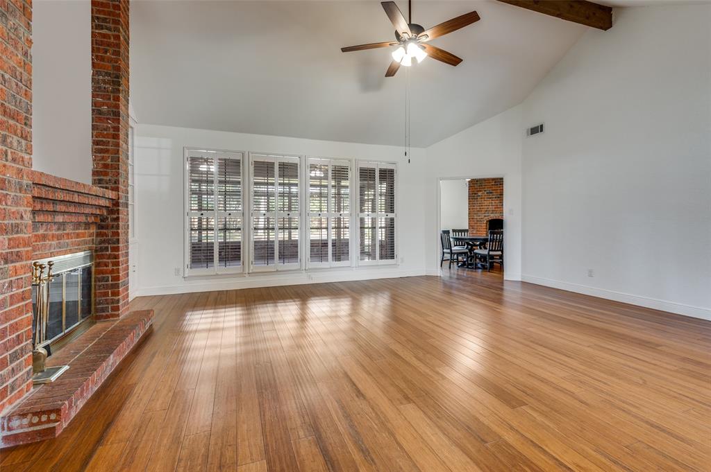 737 Newport Road Fort Worth, TX 76120 - Photo 13 of 37 Living Room with view of fireplace and wall of windows looking out to the Sun Room