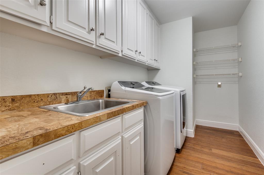 737 Newport Road Fort Worth, TX 76120 - Photo 30 of 37 Spacious Laundry Room includes built-in cabinets, shelving, and washer and dryer