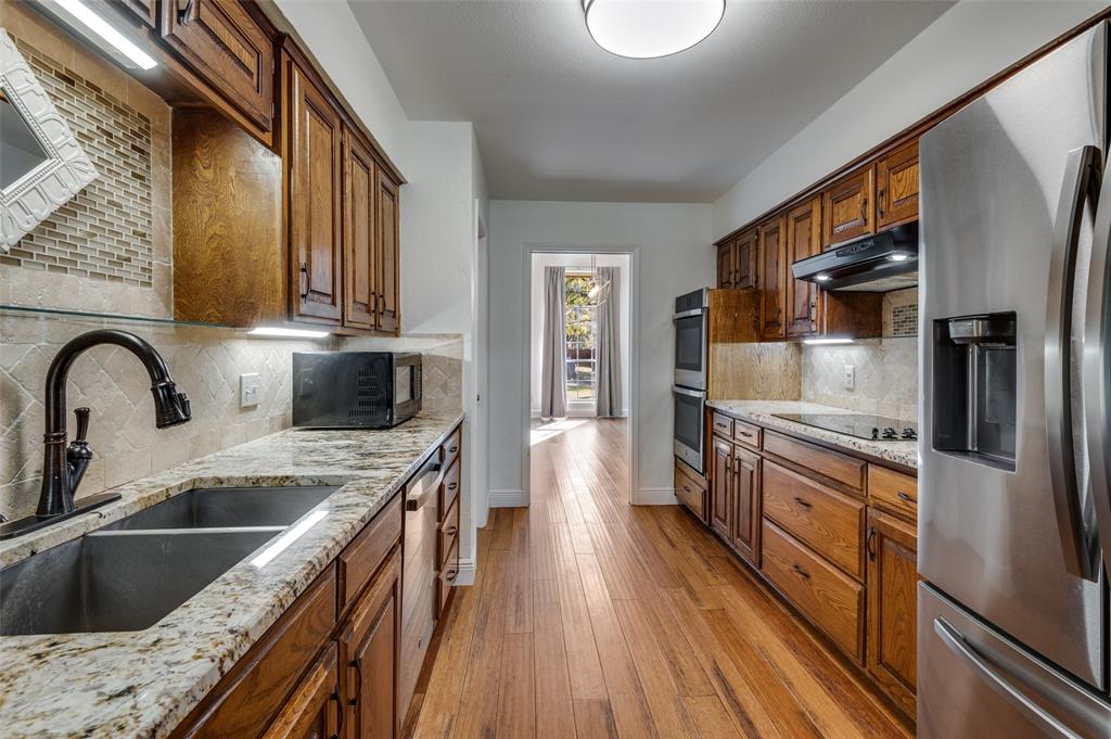 737 Newport Road Fort Worth, TX 76120 - Photo 3 of 37 The Kitchen has beautiful wood cabinets, granite countertops, and SS appliances