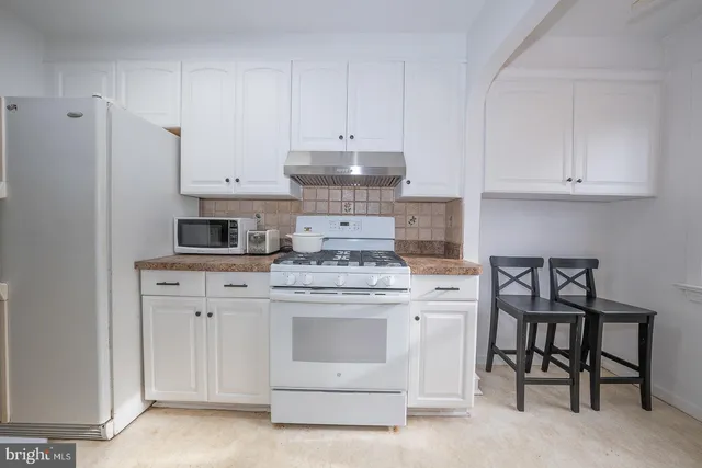 a kitchen with stainless steel appliances granite countertop a stove white cabinets and white refrigerator