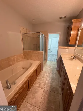 a bathroom with a tub sink and mirror