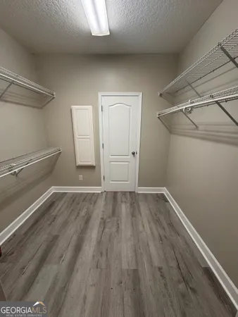 a view of walk in closet with wooden floor