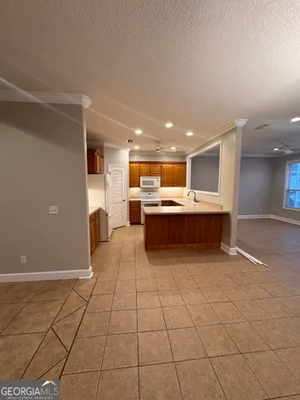 a view of kitchen with stainless steel appliances granite countertop a refrigerator and a stove top oven