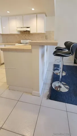 a kitchen with a refrigerator a stove and cabinets