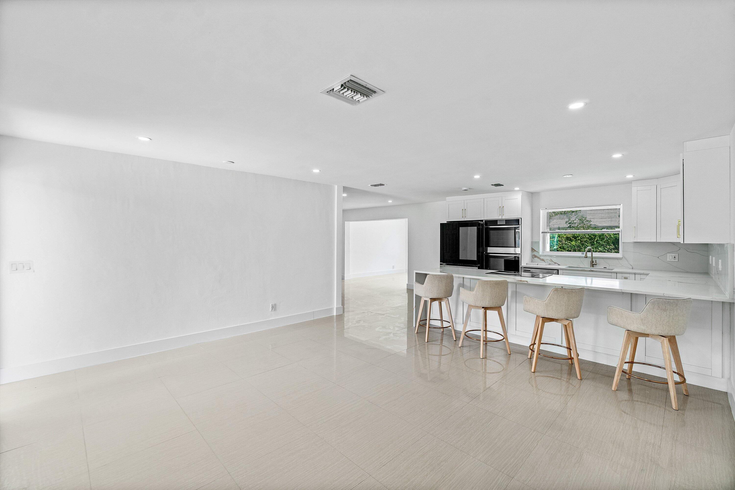 1531 Northwest 4th Street Boca Raton, FL 33486 - Photo 3 of 34 a living room with stainless steel appliances kitchen island furniture and a flat screen tv