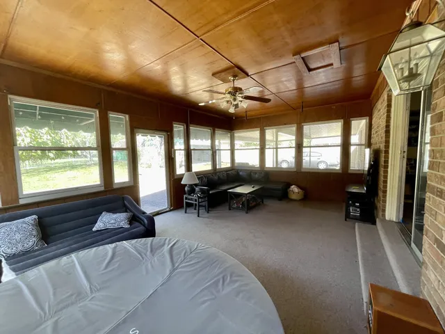 a living room with furniture ceiling fan and a large window