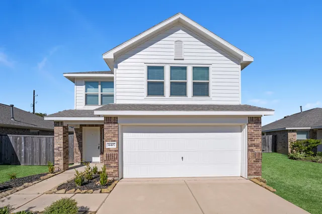 a front view of a house with a yard and garage