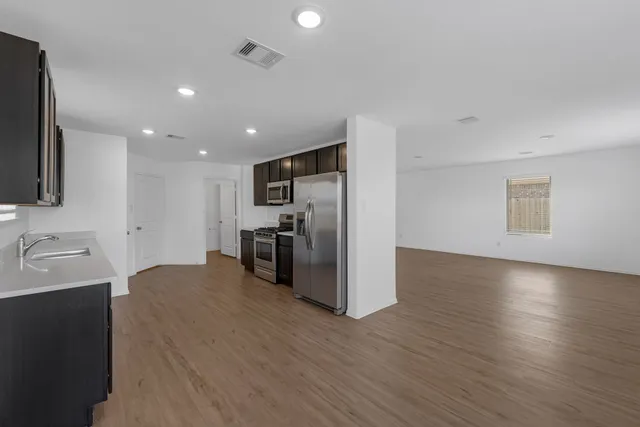 a view of a kitchen with a sink dishwasher fireplace and wooden floor