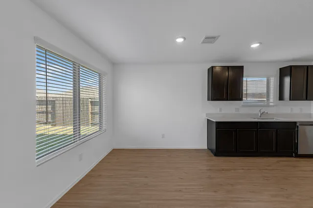a view of an empty room with a fireplace and a window