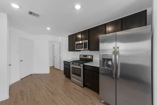 a kitchen with kitchen island a counter top space stainless steel appliances and cabinets