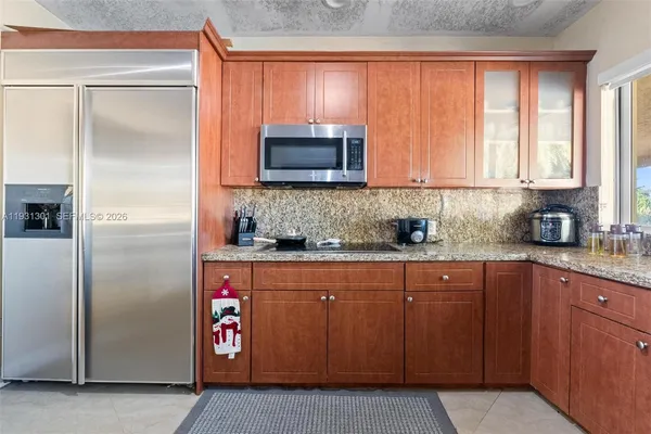 a kitchen with stainless steel appliances granite countertop a sink a stove and a refrigerator