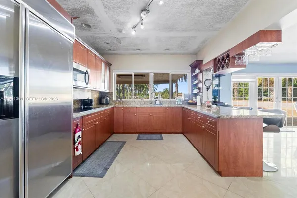 a kitchen with granite countertop wooden cabinets and a window