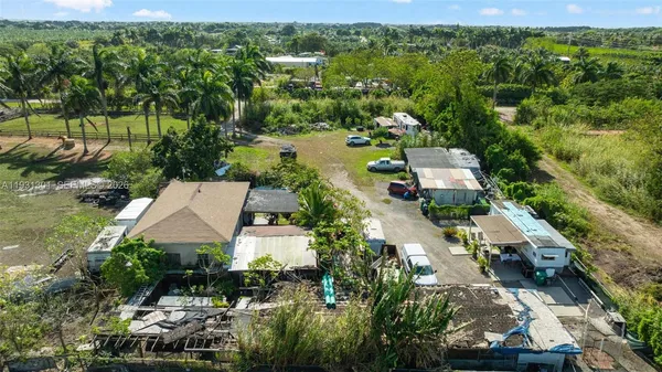 an aerial view of a house with a yard and large trees