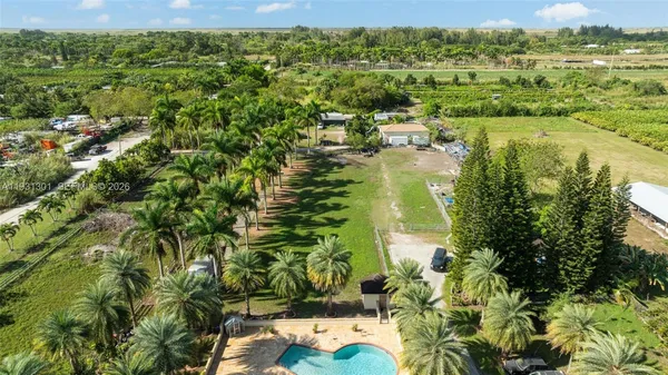 an aerial view of residential houses with outdoor space and trees
