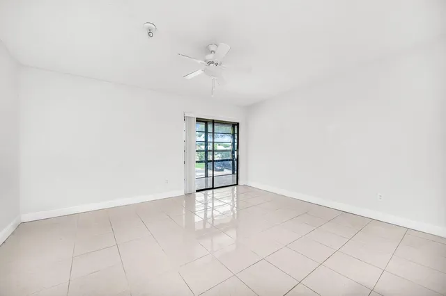 an empty room with fan and windows