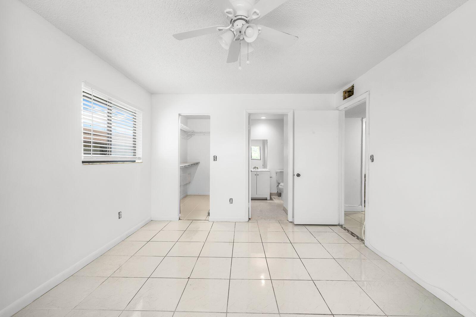 9743 West McNab Road, Unit 209 Tamarac, FL 33321 - Photo 14 of 22 a view of an empty room with window and chandelier fan