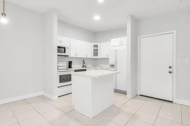 a kitchen with white cabinets and white appliances