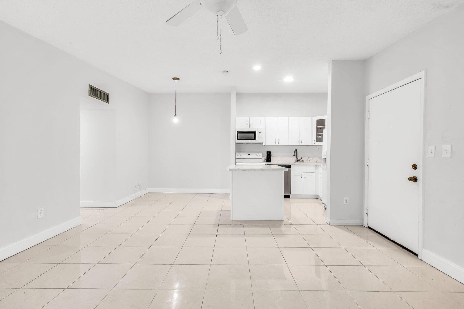 9743 West McNab Road, Unit 209 Tamarac, FL 33321 - Photo 7 of 22 a view of kitchen with white cabinets