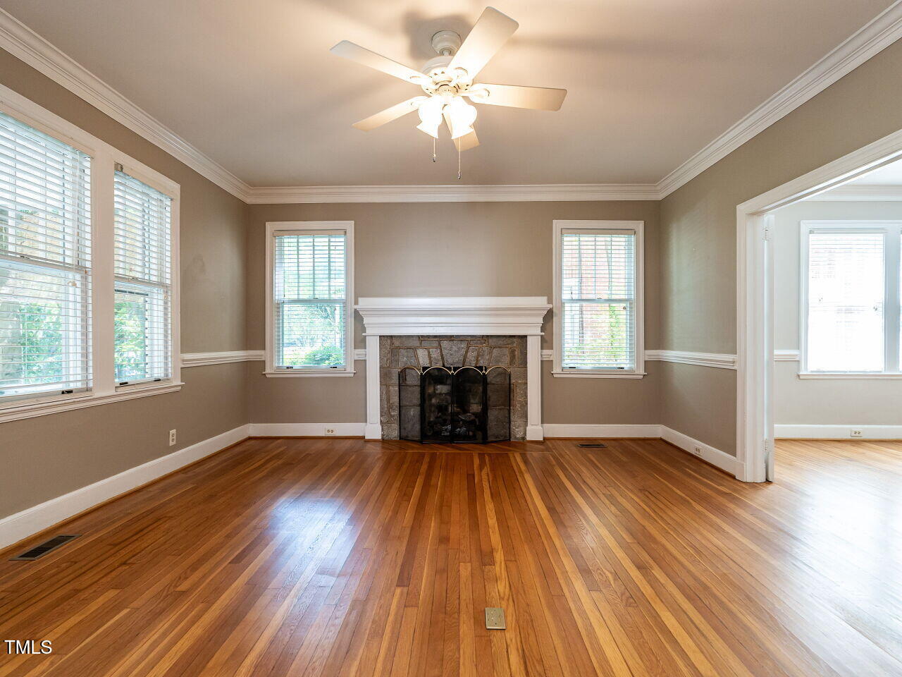 2715 Vanderbilt Avenue Raleigh, NC 27607 - Photo 6 of 36 a view of an empty room with wooden floor fireplace and a window