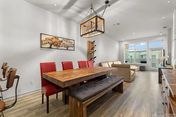 a view of a dining room with furniture a chandelier and wooden floor