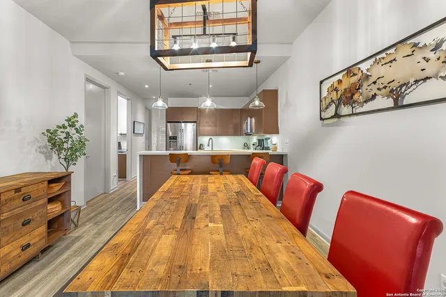 a living room with stainless steel appliances furniture and a chandelier