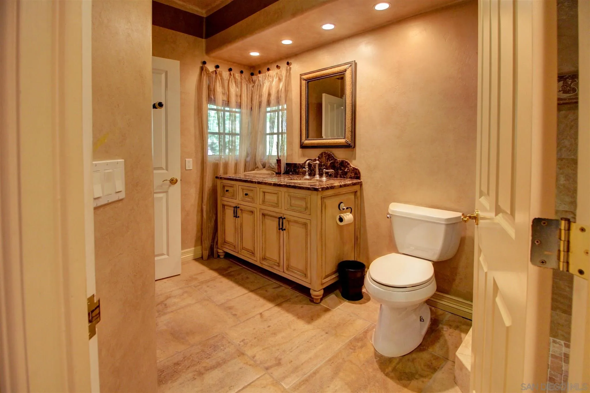 15245 Presilla Drive Jamul, CA 91935 - Photo 27 of 57 a bathroom with a granite countertop sink toilet mirror and a bathtub