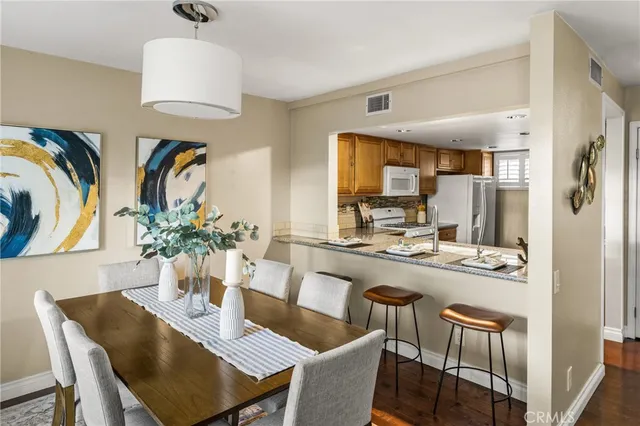 a dining room with furniture a chandelier and kitchen view
