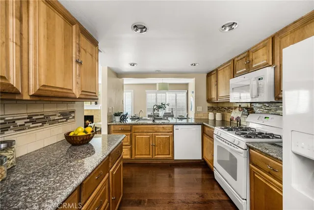 a kitchen with stainless steel appliances granite countertop a stove a sink and a white cabinets